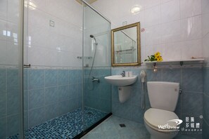 A bathroom with a glass-enclosed shower, a sink, and a toilet. - Star Shine B&B (Jiaoxi)