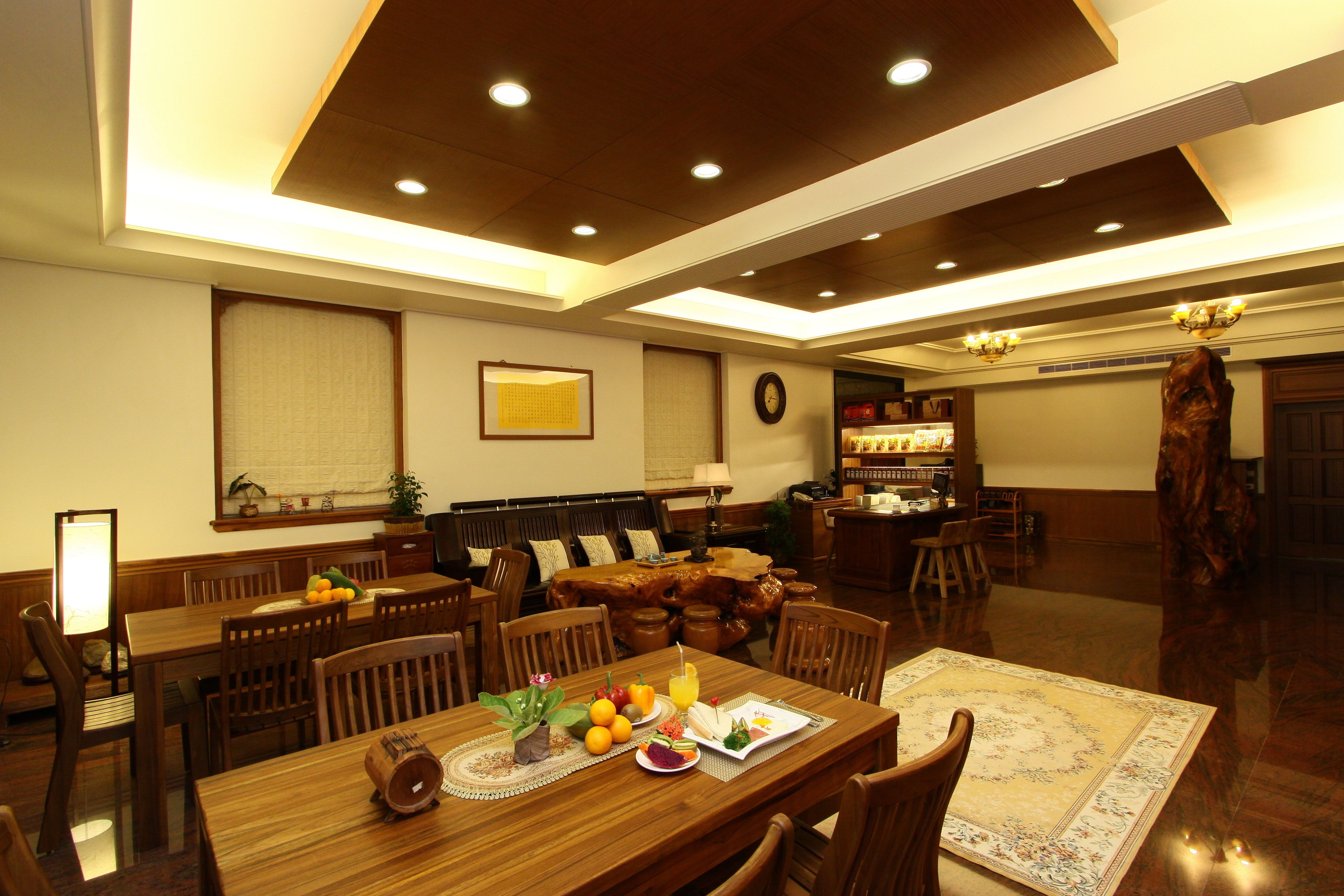 A spacious dining area with wooden furniture, a large dining table, and a cozy seating arrangement.