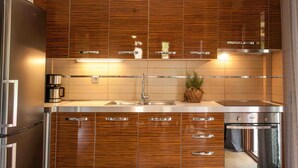 Une cuisine moderne avec des meubles en bois, des appareils en acier inoxydable et un four encastré.