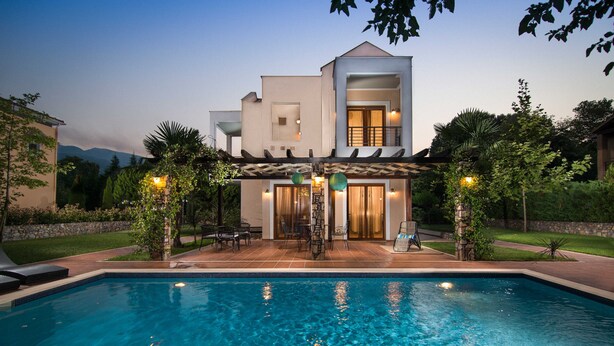 Une maison moderne à deux étages avec une piscine à l’avant.