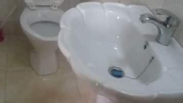 Bañera con ducha, toallas, jabón, papel higiénico
