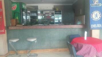 A bar area with stools, a table with a red tablecloth, and a sign for Chelsea Football Club.