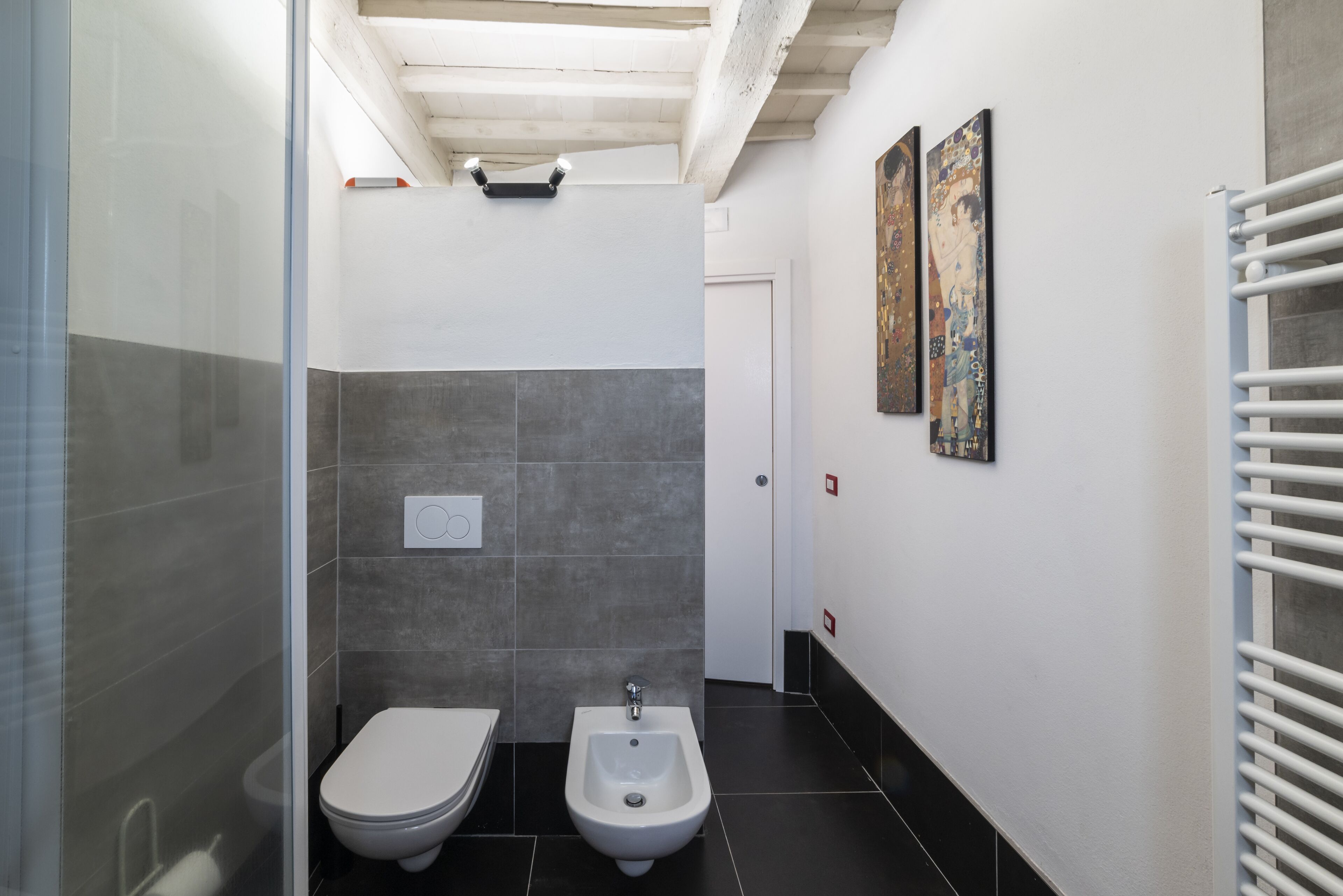 Ein modernes Badezimmer mit Toilette, Bidet und Duschkabine aus Glas.