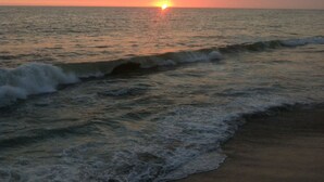 A sunset over the ocean with waves approaching the shore. - Beautiful Private Beachfront Villa (Nuevo Mazatlan)