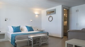 Ein Schlafzimmer mit einem Bett, Nachttischen, einer Bank, einem Kleiderschrank und einem Spiegel.
