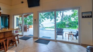 Een hotel lobby met een receptiebalie, een televisietoestel en een bord waarop 'Beach House' staat.