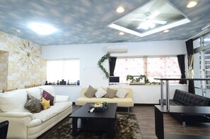 A living room with two sofas, a coffee table, and a TV. - South Island (Itoman)