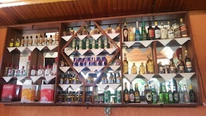 Un bar con estantes llenos de botellas y cajas de licores.