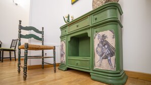 A green wooden cabinet with a decorative panel featuring a knight. - Natoli Apartments - Gigi House (Palermo, Italia)