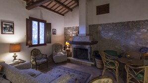 A cozy living room with a fireplace, wooden beams, and rustic decor. - Marotta Chalet, on the slopes of Erice (Valderice)
