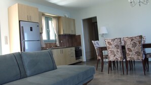 Eine moderne Küche mit Einbaukühlschrank, Holzschränken und einem Essbereich mit gemusterten Stühlen und einem Tisch.