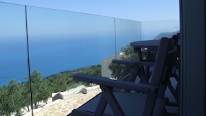 Ein Balkon mit freiem Blick auf das Meer und eine gebirgige Landschaft.