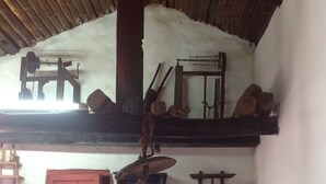 Eine rustikale Küche mit Holzmöbeln, einer roten Tür und verschiedenen Küchenutensilien, die an der Wand hängen.