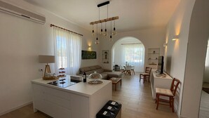 Een modern appartement met een centraal eiland, een eetgedeelte en een woonkamer.