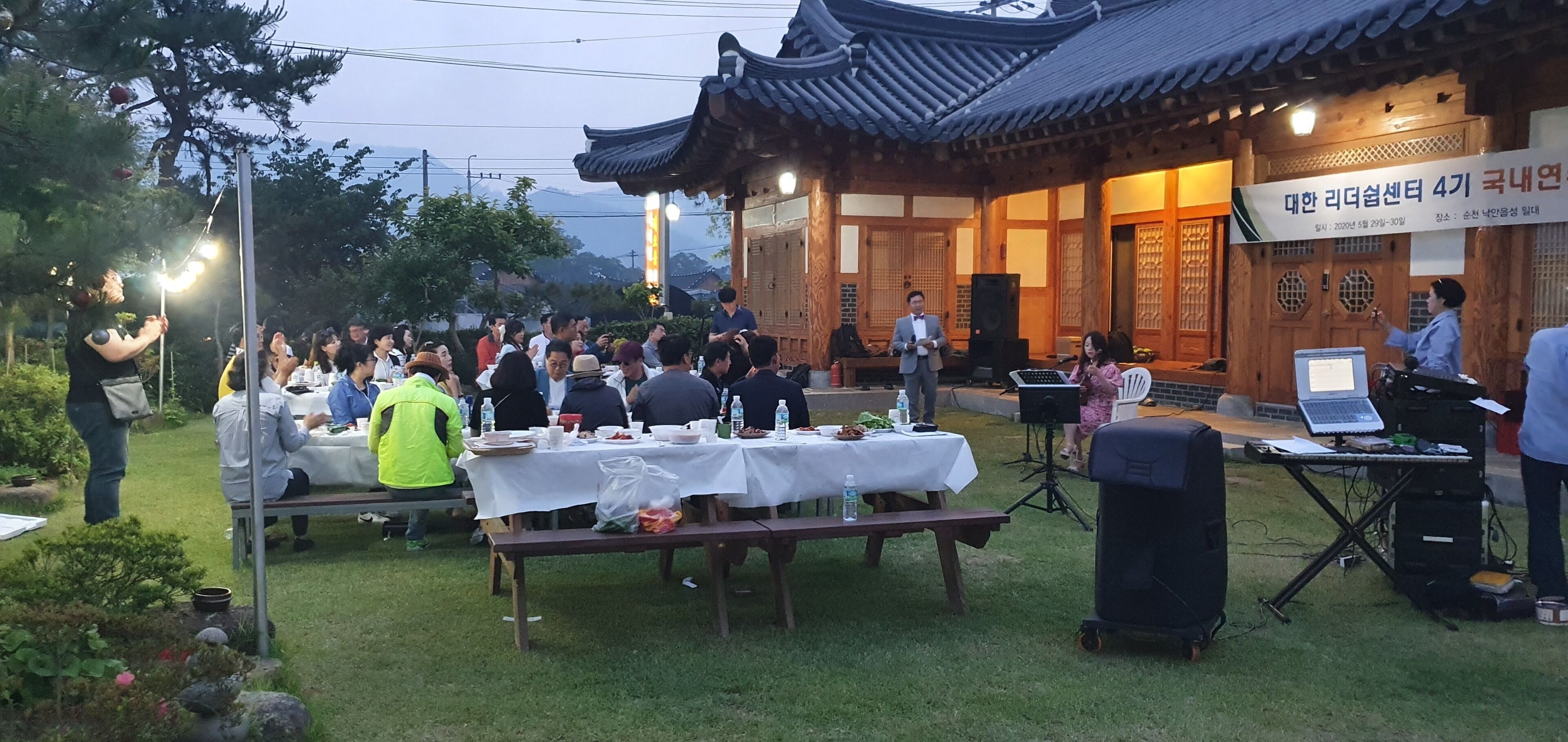 An outdoor dining area with tables set for a meal, surrounded by traditional wooden architecture.