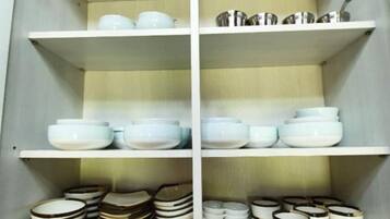 Um armário de cozinha com prateleiras contendo utensílios domésticos.