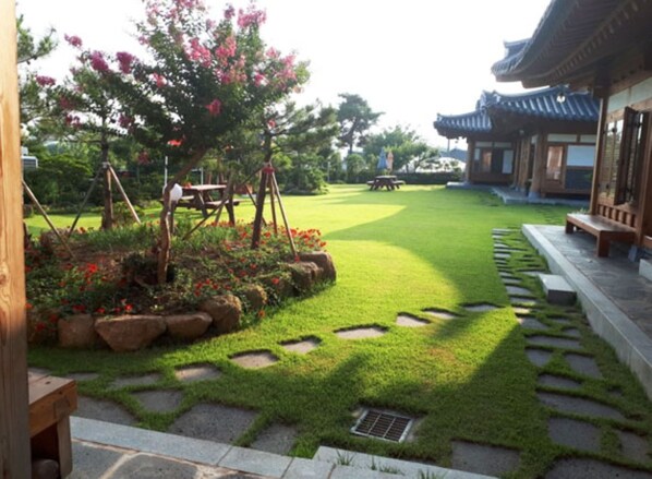 A traditional Korean-style building with a well-maintained lawn and stone pathways.