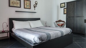 A modern bedroom with a large bed, a wardrobe, and artwork on the walls. - Mini Apartments in Brindisi center Corso Garibaldi (Brindisi)