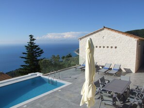 A swimming pool with a view of the sea, lounge chairs, and a white building with a tiled roof. - SAPPHIRE SUPERIOR VILLA - AGIOS NIKITAS LEFKADA (Δρυμώνας)