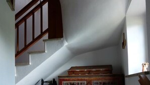 A staircase leading to a landing with a wooden bench and a chest of drawers. - MASO PINTERATO - Narciso apartment (Cavalese)