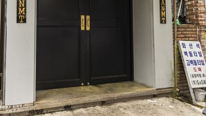Señal de SALIDA sobre una puerta negra con las indicaciones 'ENTRAR' y 'SALIDA'.