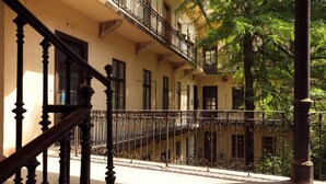 A multi-story building with a balcony, a staircase, and a street view.