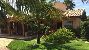 A covered outdoor seating area with a wooden deck, surrounded by lush greenery and a palm tree. - BEAUTIFUL PROPERTY IN PORTO FELIZ (Porto feliz)