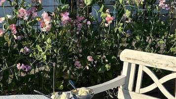 Enjoy a casual meal in the garden, surrounded by blooming flowers and a comfortable bench.