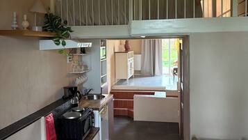 A compact living space with a kitchenette, a dining area, and a small seating area.