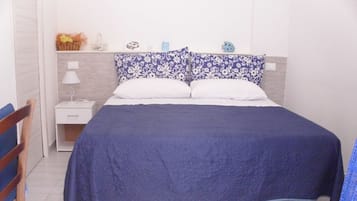 Une chambre à coucher comprenant un lit, une table de chevet, une chaise et un mur décoré de différents objets.