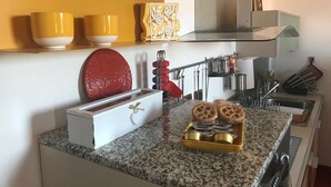 Eine Küche mit Granit Arbeitsplatten, einem Toaster, einem roten Dekorations Teller und einer Schale mit Keksen.