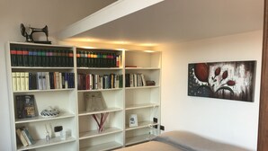Ein Schlafzimmer mit einem Bett, einem Bücherregal und einem Gemälde.