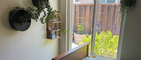Un dormitorio con una cama, una ventana y vistas a un jardín.