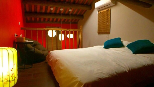 A bedroom with a bed, pillows, a desk, and a chair. - Zhu Shan Homestay (Jincheng)