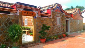 A traditional building with a tiled roof and a sign indicating a restaurant. - Zhu Shan Homestay (Jincheng)