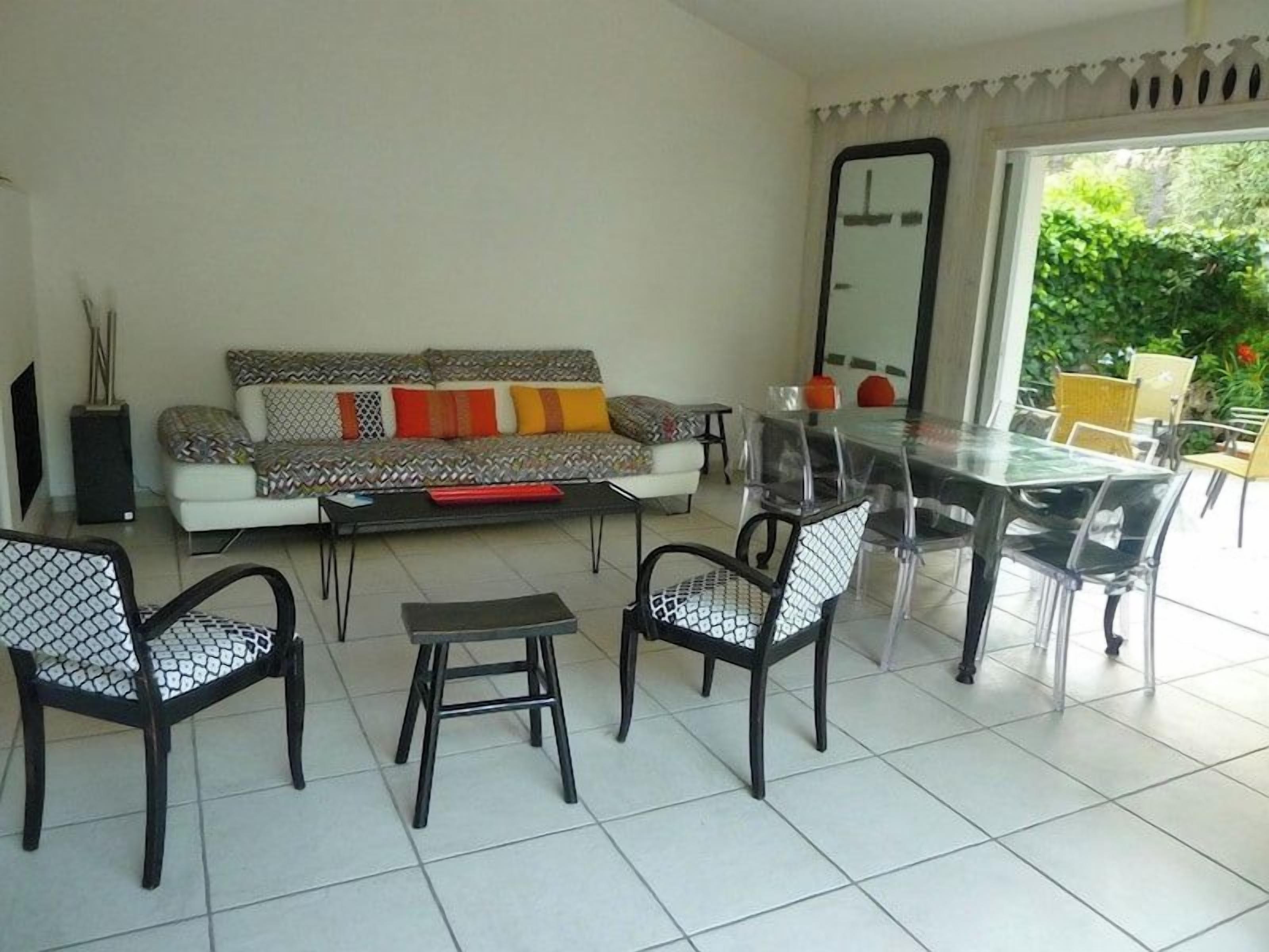 Un salon comprenant un canapé, une table basse, des fauteuils et une table à manger.