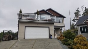 A two-story house with a white garage door, a balcony with white railings, and a number '742' on the garage door. - Executive Suite with commanding views - Claudette Ct. (Victoria)