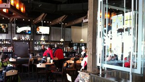 A bar with wooden furniture, a television screen, and a brick wall. - Spring Break, Ski-in/out, 5-star, 2BR, sleeps 8 (Breckenridge)