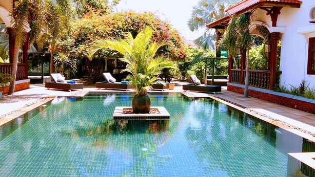 A pool with lounge chairs and a palm tree. - Eureka Villas Siem Reap (Siem Reap)