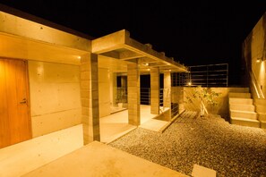 A modern building with a covered outdoor area, a staircase, and a small garden. - The:MOVES-Musée Villa- (Nakijin)