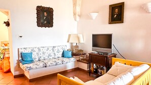 Ein Schlafzimmer mit Bett, Sofa, Fernseher und Lampe.