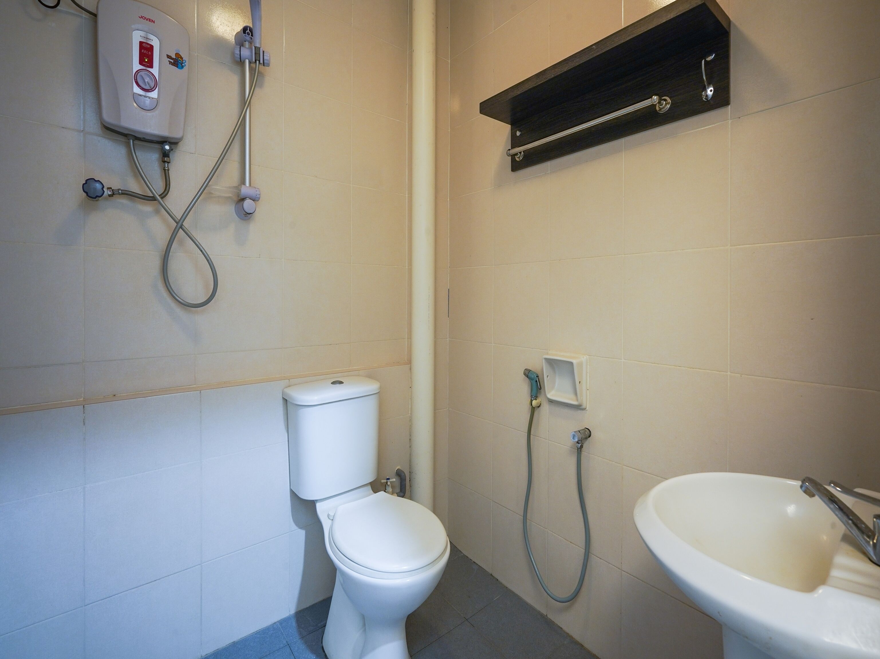 A bathroom with a toilet, a shower, and a sink.