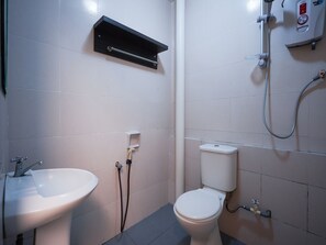 A bathroom with a white sink, toilet, and a shower unit. - Hotel O Hotel Orchard Inn (Lumut)