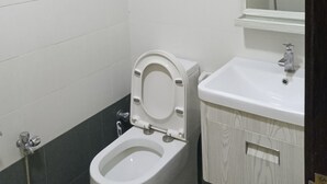 Une salle de bain avec des toilettes, un lavabo et un miroir.