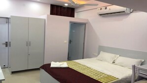 Une chambre à coucher comprenant un lit, une armoire, un climatiseur et un ventilateur de plafond.