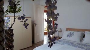 Une chambre à coucher comprenant un lit, une armoire et une porte donnant sur un espace extérieur.