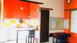 A compact kitchen with a microwave, a sink, and a hanging light fixture. - Apartment in Historic Downtown Quito (Quito)