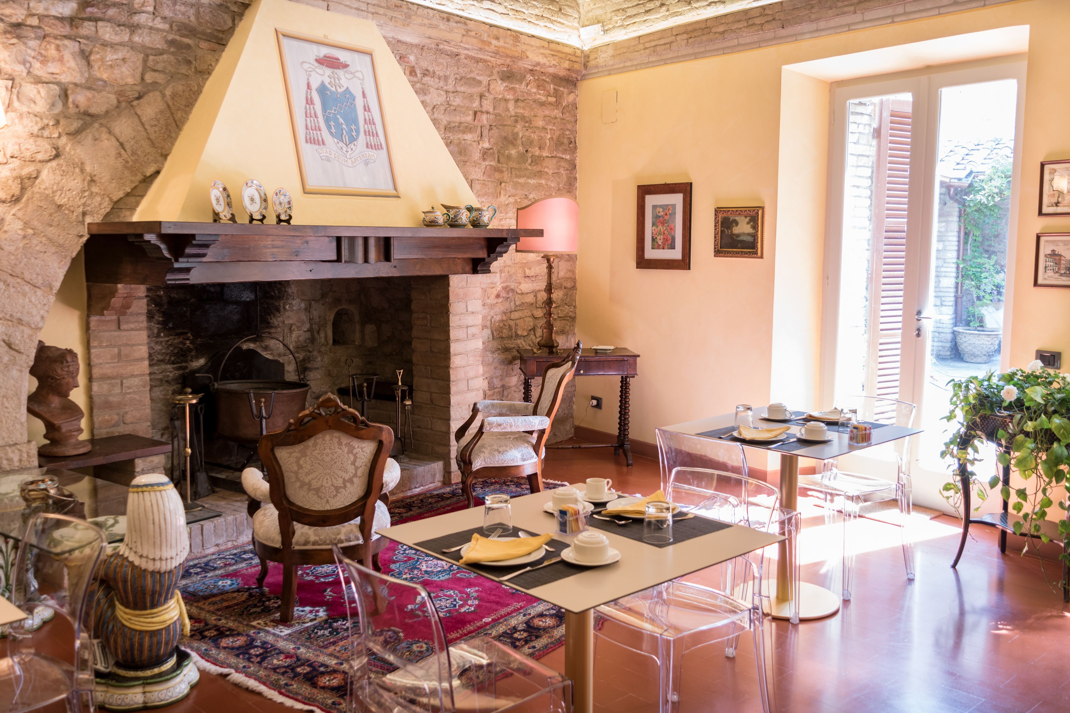 Un comedor con chimenea, sillas traslúcidas, una mesa para dos y vistas al exterior.