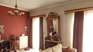 Uma sala de estar com sofá, mesa de centro, lareira e um espelho grande.