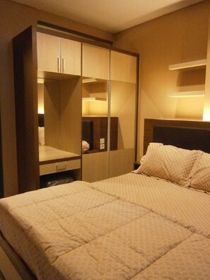 Relax in comfort with a spacious bed and ample storage in this stylish room.